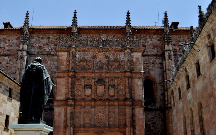 La Universidad de Salamanca_(4852577370)_autor_katiebordner_30 junio 2010_source_universidad de salamanca_CC 2.0 attribution Fachada de la Universidad de Salamanca con la estatuta de Fray Luis de León enfrente.