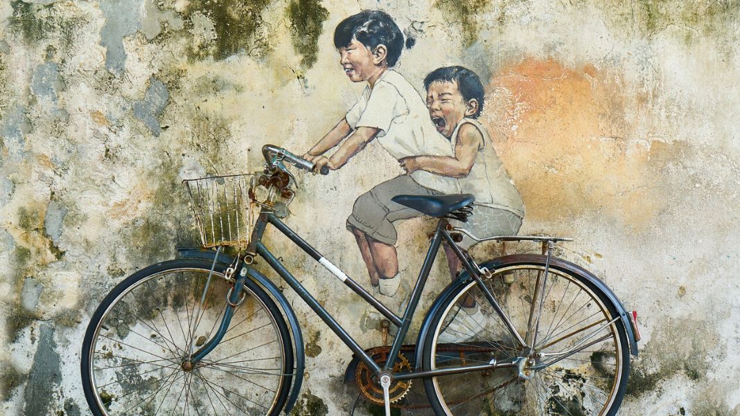 Infancia es destino Niños en bicicleta, representando Infancia es destino. Diseño realizado a partir de la fotografía de Engin_Akyurt (extraída de Pixabay, CC0)